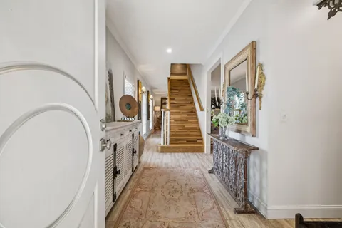 a view of a hallway with wooden floor and entryway