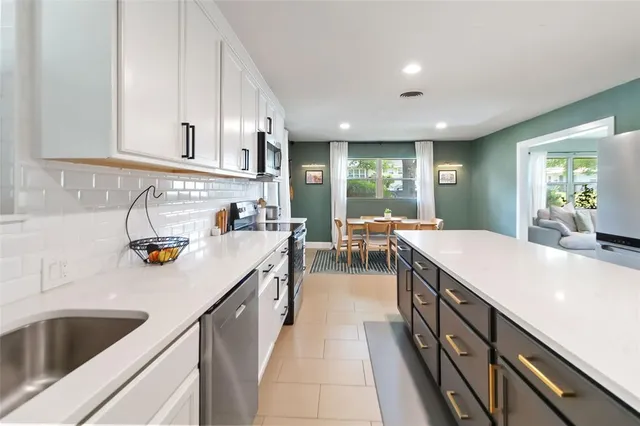 a kitchen with counter top space a sink stainless steel appliances and windows