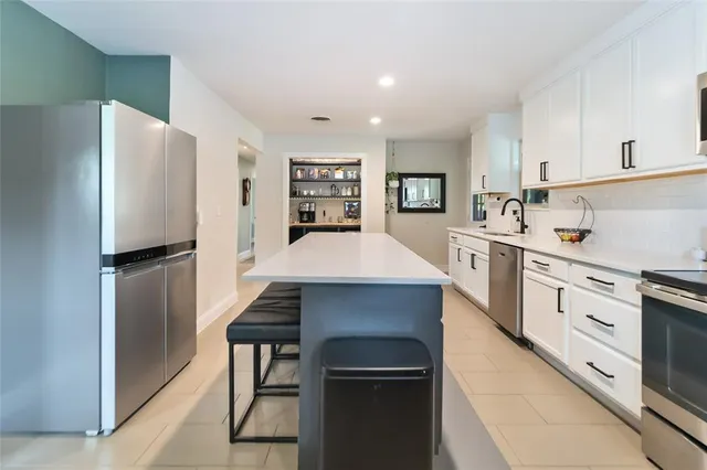 a kitchen with stainless steel appliances a refrigerator and a stove top oven