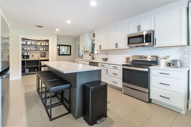 a kitchen with stainless steel appliances a stove sink microwave and cabinets