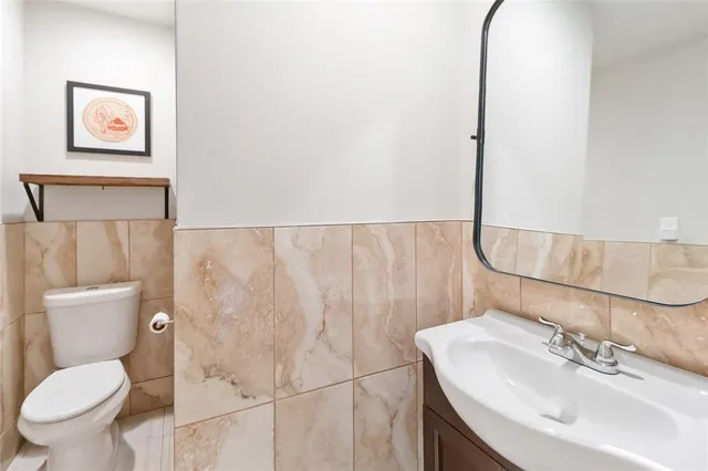 a bathroom with a toilet sink and mirror