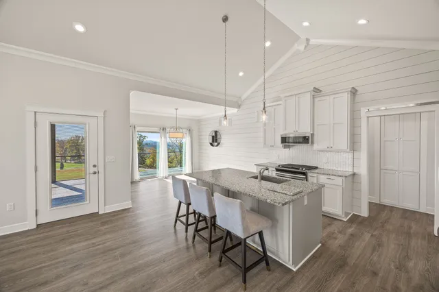 a kitchen with stainless steel appliances granite countertop a stove a refrigerator and a stove top oven