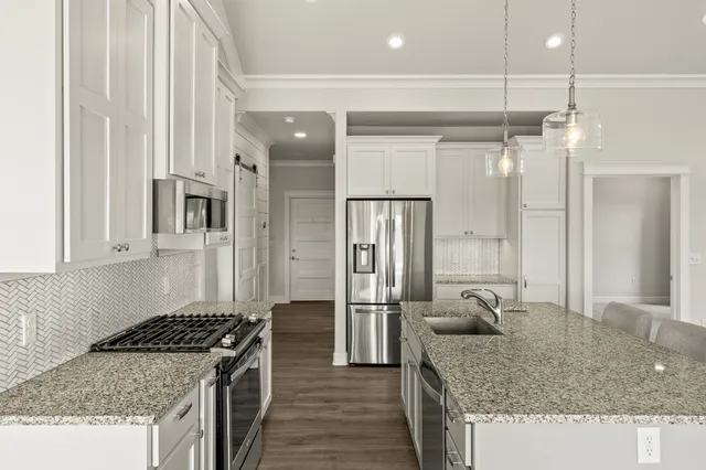 a kitchen with stainless steel appliances granite countertop a sink stove and refrigerator