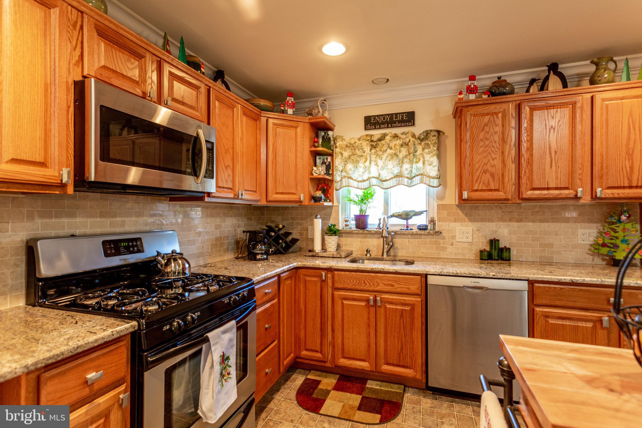 1619 West County Line Road Hatboro, PA 19040 - Photo 8 of 30 a kitchen with stainless steel appliances wooden cabinets and a stove top oven