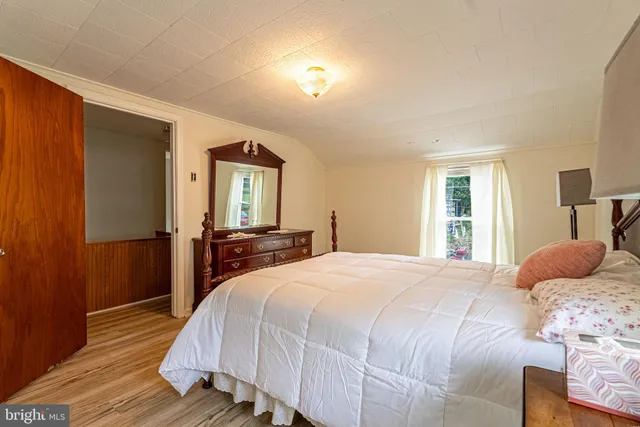 a bedroom with a bed and wooden floor