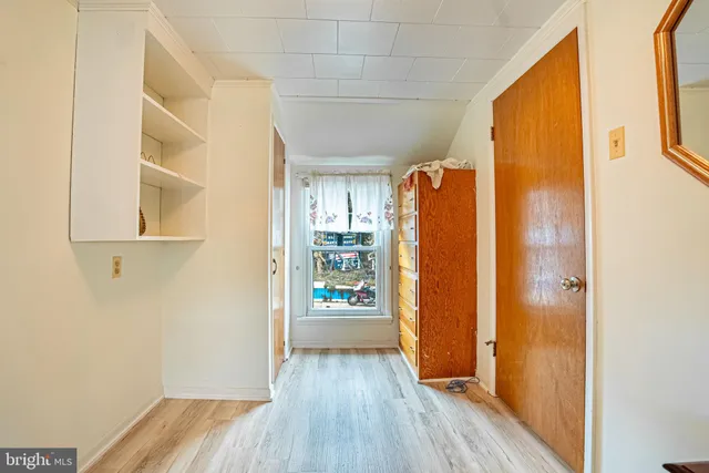 a view of a hallway with wooden floor and a window