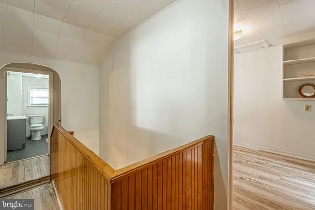 a view of a hallway with entryway and wooden floor