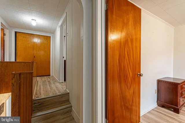 a view of a hallway with wooden floor and staircase