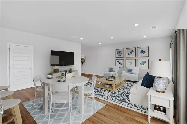 a living room with stainless steel appliances a table and chairs