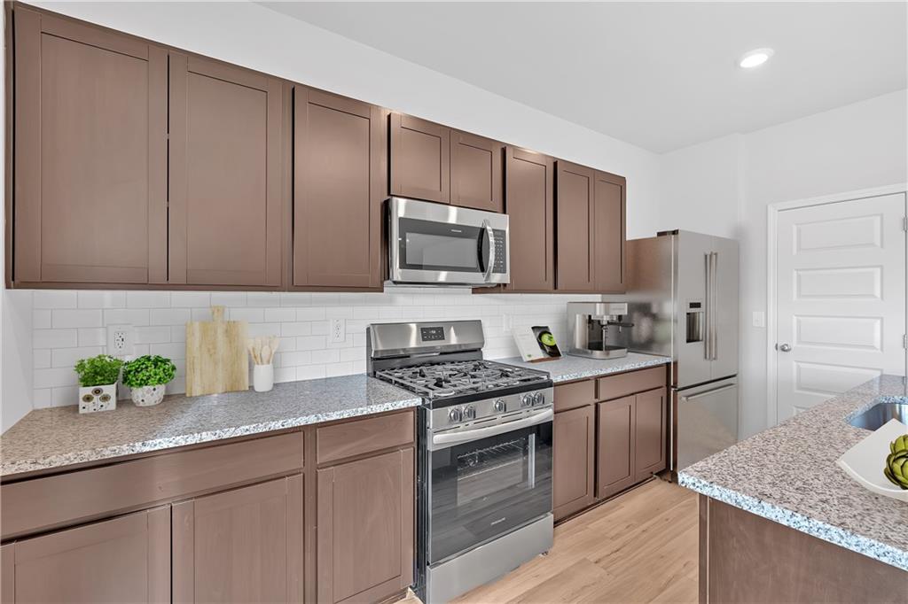 107 Lavender Circle Calhoun, GA 30701 - Photo 8 of 23 a kitchen with granite countertop cabinets stainless steel appliances and a counter space