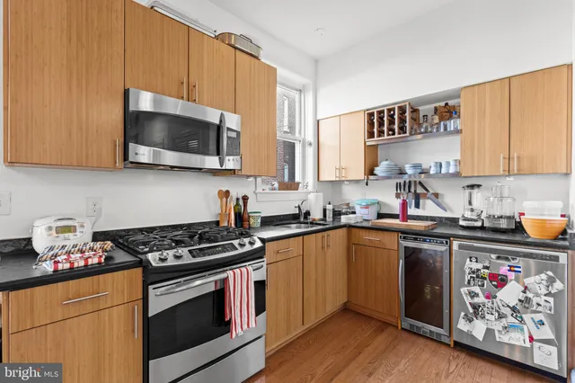 a kitchen with stainless steel appliances a stove a sink and cabinets