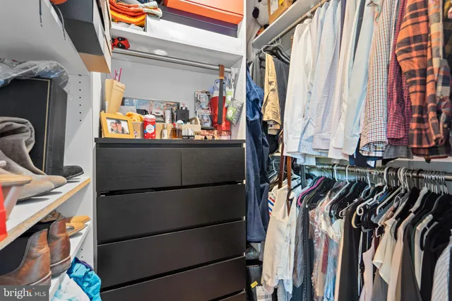 a view of walk in closet with clothes and shoes
