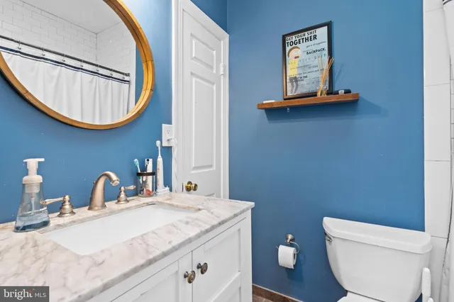 a bathroom with a toilet a sink and mirror