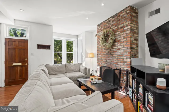 a living room with furniture a flat screen tv and a fireplace