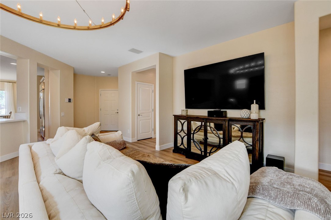 2649 Rue Marquette Avenue Henderson, NV 89044 - Photo 13 of 55 An inviting living area with a sleek entertainment center and warm wood flooring.