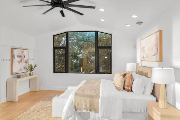 a bedroom with a large bed and a window