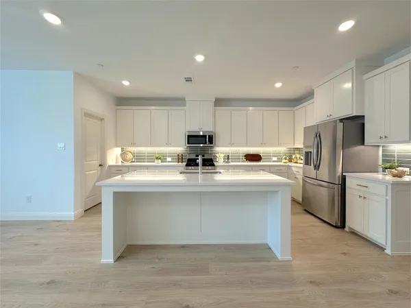 a kitchen with a sink stainless steel appliances and white cabinets