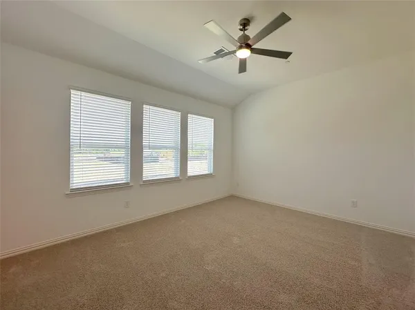 an empty room with a window and a fan