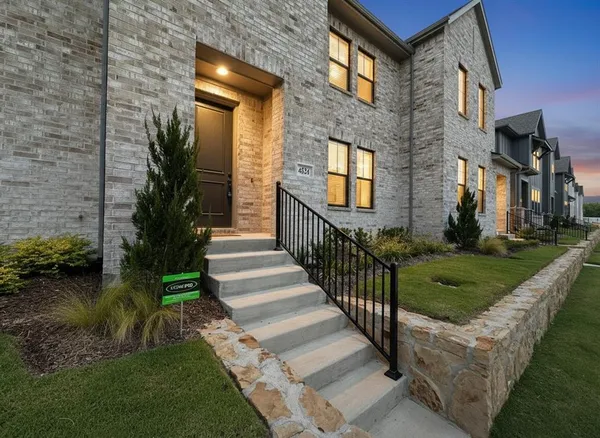 a view of a brick house with a yard to stairs