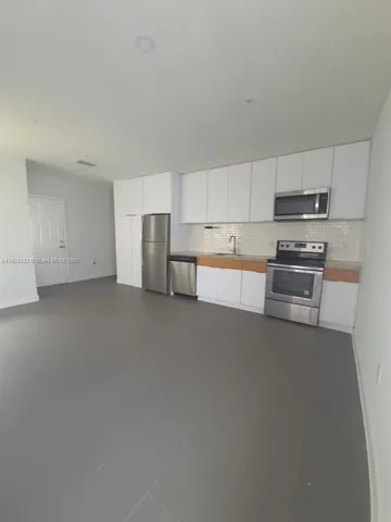 a kitchen with refrigerator a washer and dryer