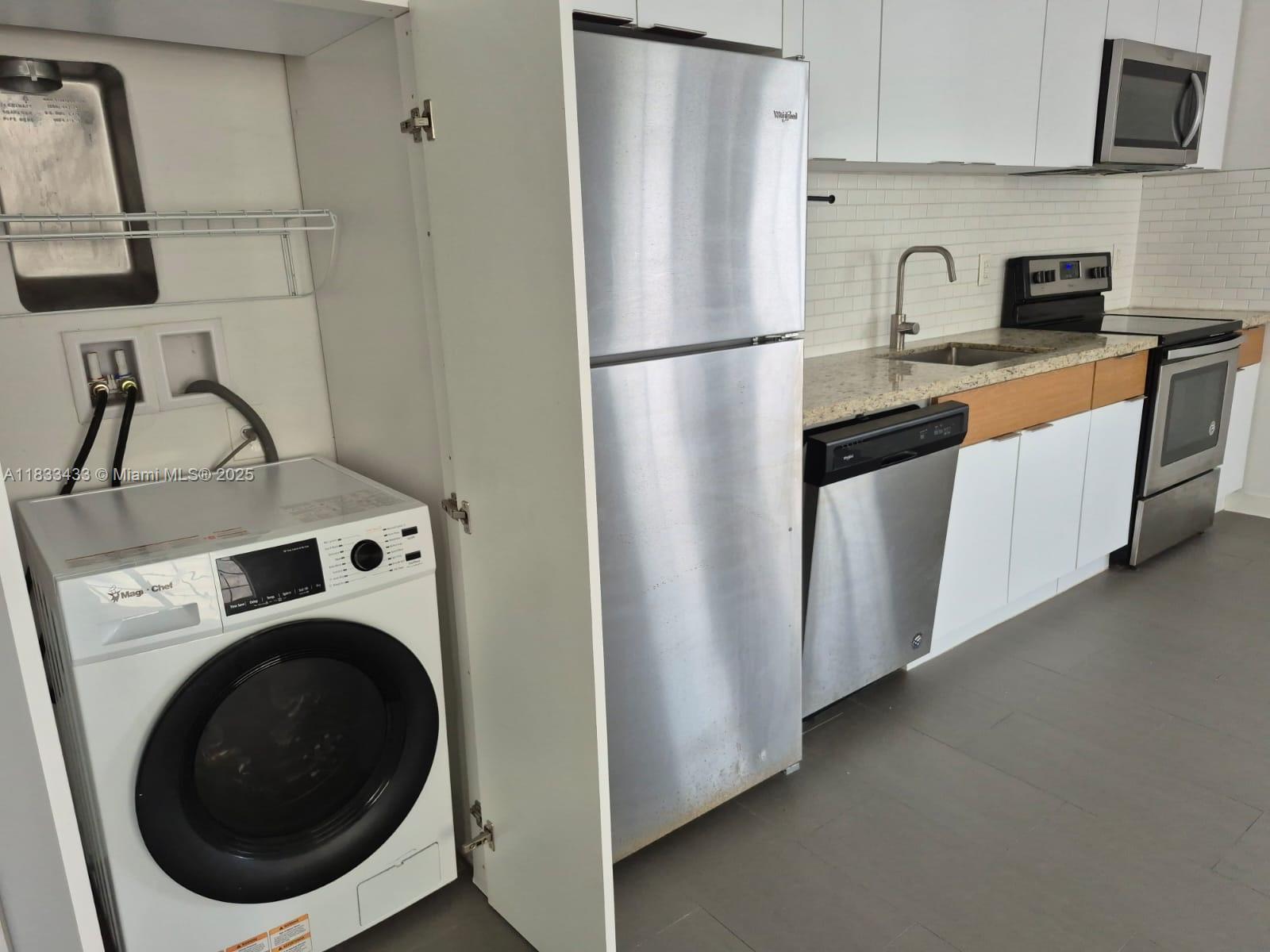 1211 Euclid Avenue, Unit 11 Miami Beach, FL 33139 - Photo 7 of 19 a kitchen with refrigerator a washer and dryer
