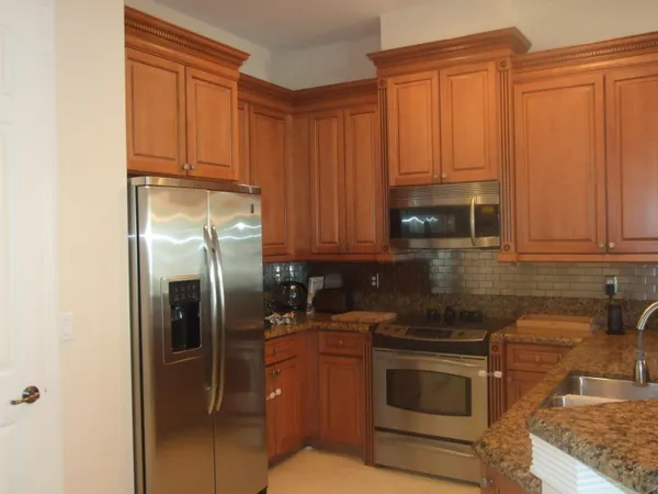 a kitchen with stainless steel appliances granite countertop a refrigerator stove and sink