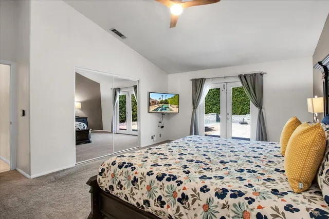 a bedroom with a bed and a large mirror with window