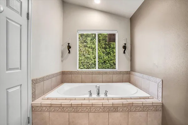 a white bath tub sitting in a bathroom next to a window