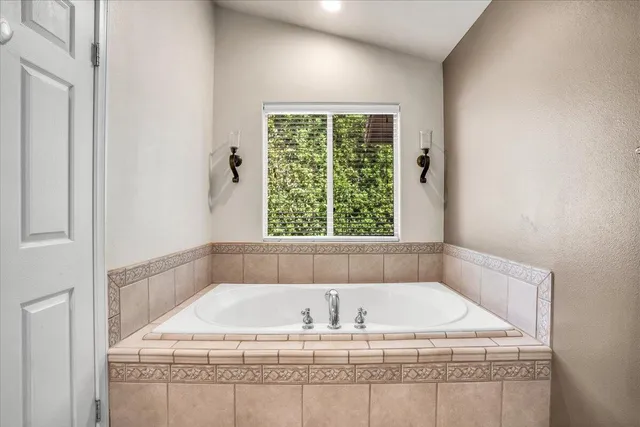 a white bath tub sitting in a bathroom next to a window