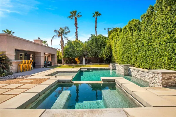 a view of swimming pool with a lounge chairs