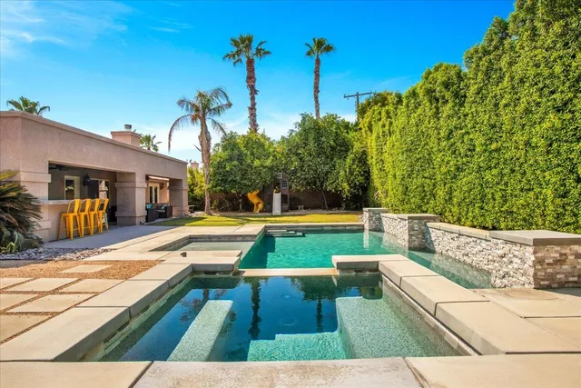 a view of swimming pool with a lounge chairs
