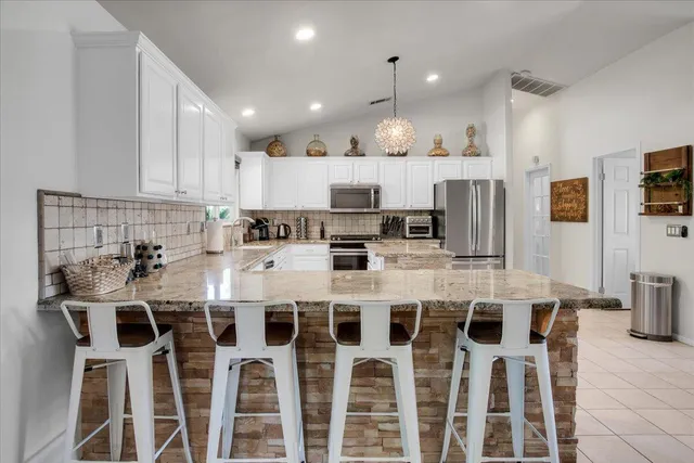 a kitchen with stainless steel appliances kitchen island granite countertop a sink and cabinets