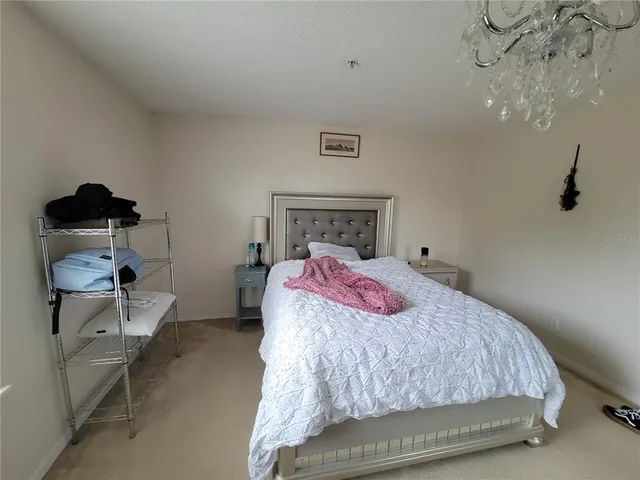 a bedroom with a bed and a chandelier