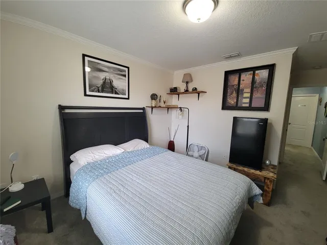a bedroom with a bed and a painting on the wall
