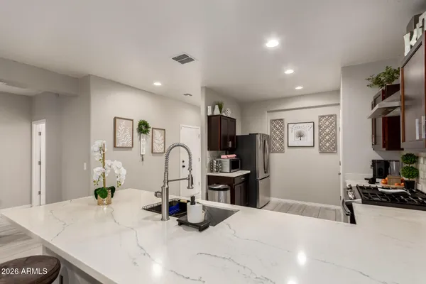 a kitchen with stainless steel appliances kitchen island granite countertop a refrigerator and a sink
