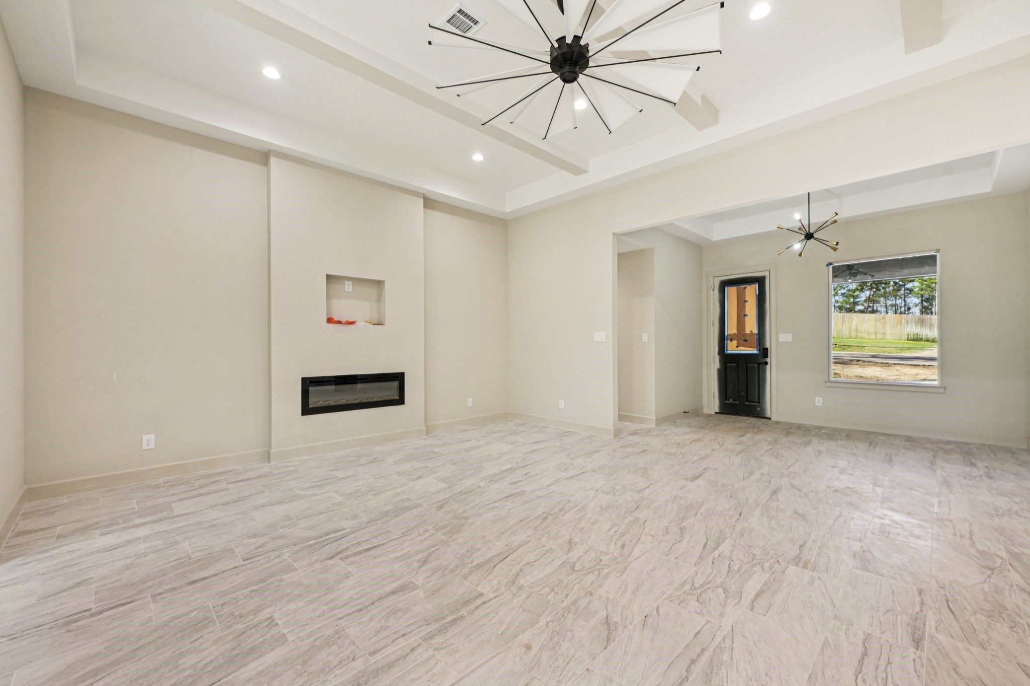 15132 Coaltown Road Willis, TX 77378 - Photo 3 of 29 View of the Family area features modern tile flooring, electric fireplace, and large windows for natural light.