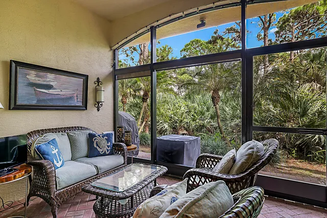 a living room with furniture and a floor to ceiling window