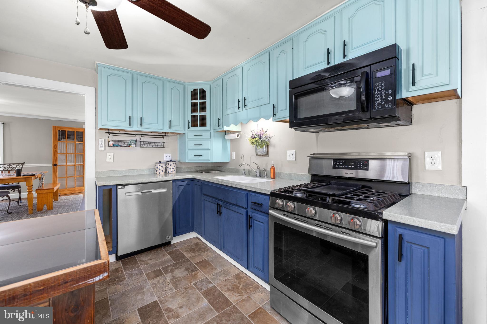 9973 Champ Road Princess Anne, MD 21853 - Photo 5 of 28 a kitchen with stainless steel appliances granite countertop a stove microwave sink and refrigerator