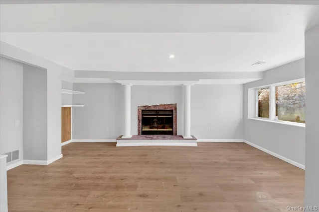 a view of an empty room with a window and fireplace