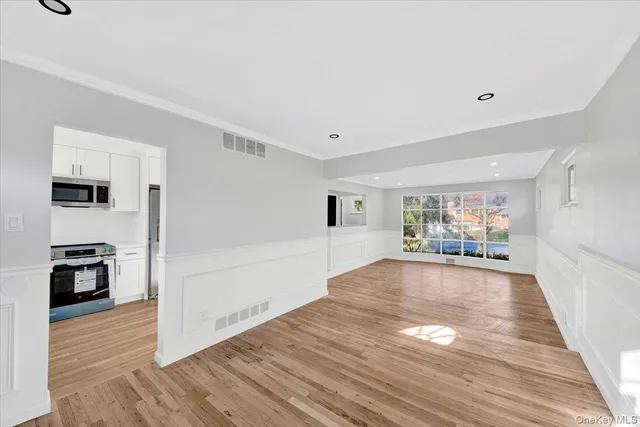 a view of a livingroom with wooden floor and furniture