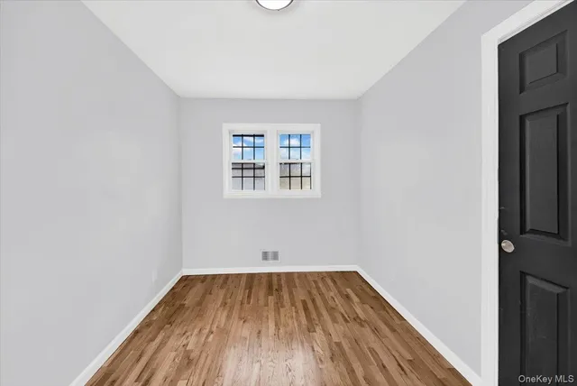 a view of a room with wooden floor and window