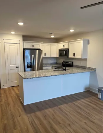 a kitchen with granite countertop a stove and cabinets