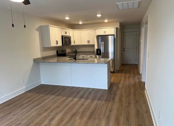 a kitchen with stainless steel appliances granite countertop a sink stove and refrigerator