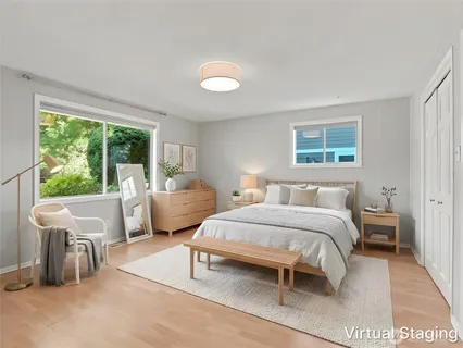 a bedroom with a bed and large windows