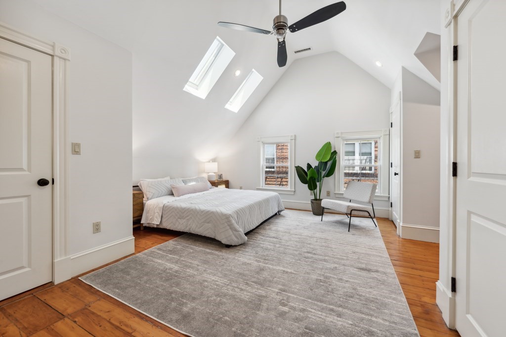 7 Haskell Street, Unit B Cambridge, MA 02140 - Photo 15 of 23 a spacious bedroom with a bed and a chandelier
