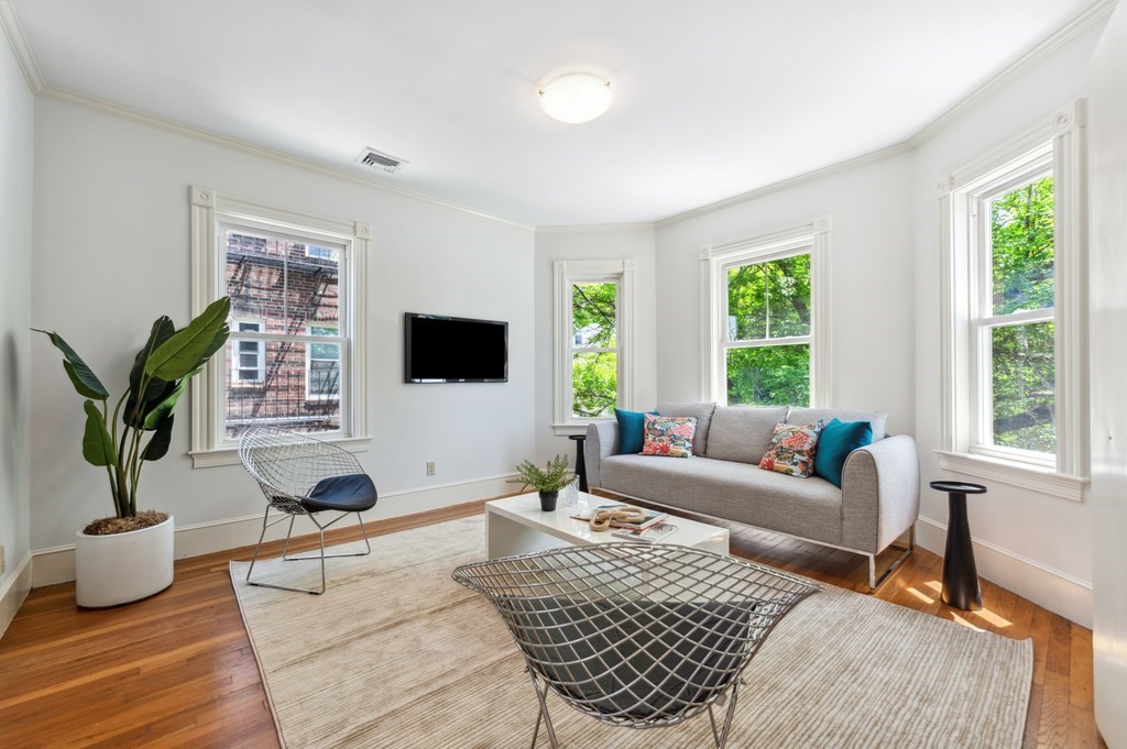 7 Haskell Street, Unit B Cambridge, MA 02140 - Photo 3 of 23 a living room with furniture a flat screen tv and a large window