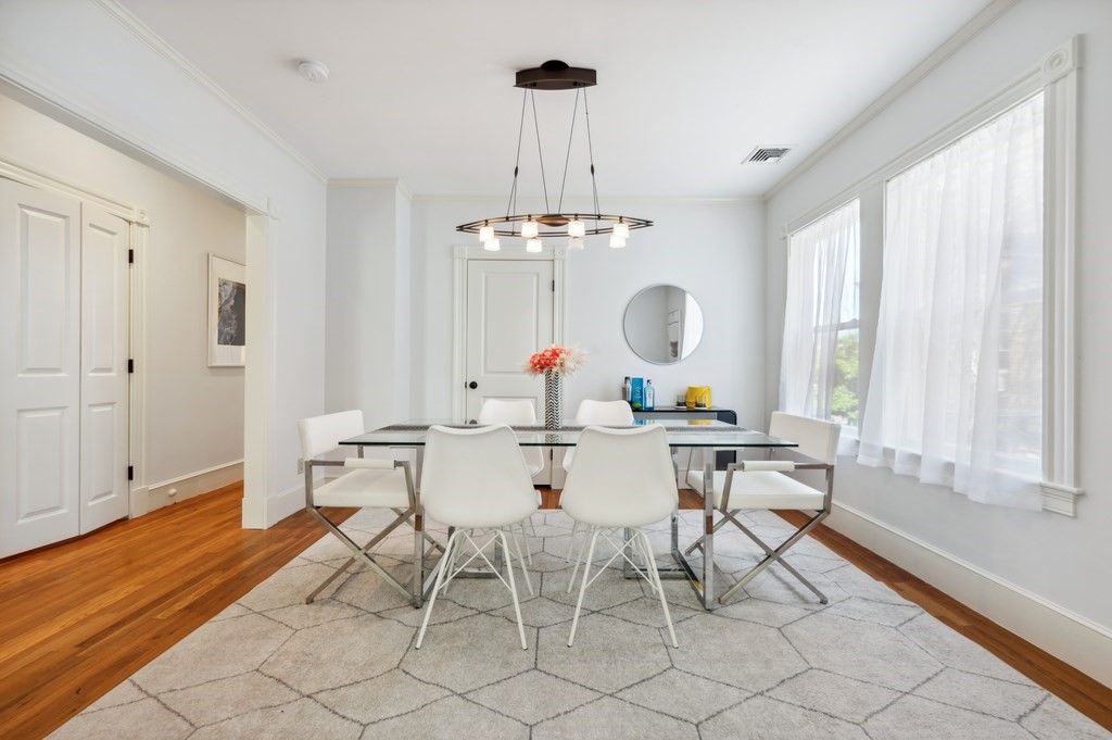 7 Haskell Street, Unit B Cambridge, MA 02140 - Photo 5 of 23 a dining room with wooden floor a chandelier a wooden table and chairs