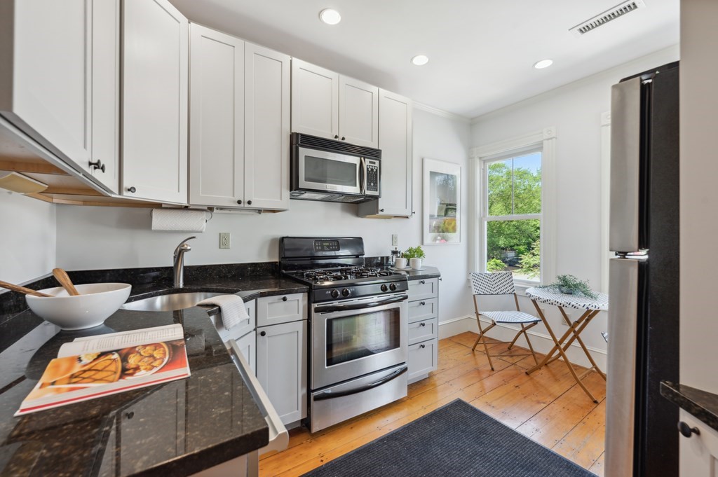 7 Haskell Street, Unit B Cambridge, MA 02140 - Photo 7 of 23 a kitchen with stainless steel appliances granite countertop a stove a sink and a microwave