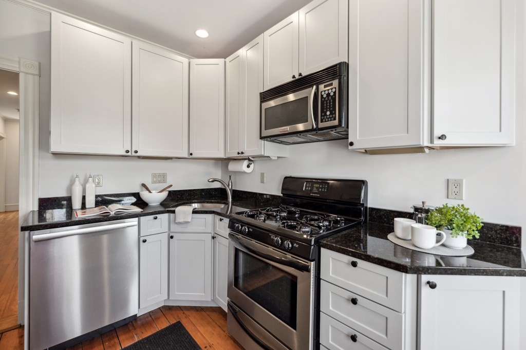 7 Haskell Street, Unit B Cambridge, MA 02140 - Photo 8 of 23 a kitchen with stainless steel appliances granite countertop a sink a stove a microwave and cabinets