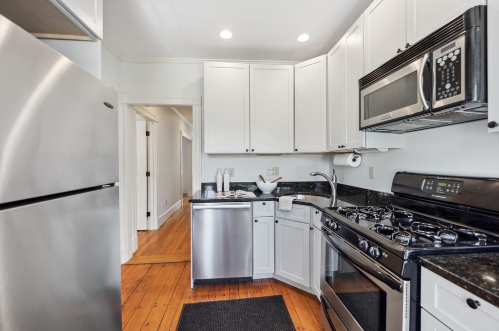 7 Haskell Street, Unit B Cambridge, MA 02140 - Photo 9 of 23 a kitchen with stainless steel appliances a stove a microwave and a refrigerator
